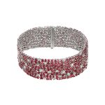 A magenta colored bracelet with gems on it